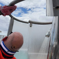 Ship Cleaning Operative cleans the dirt, grease and limescale from the steel fixtures of a pool-side shower